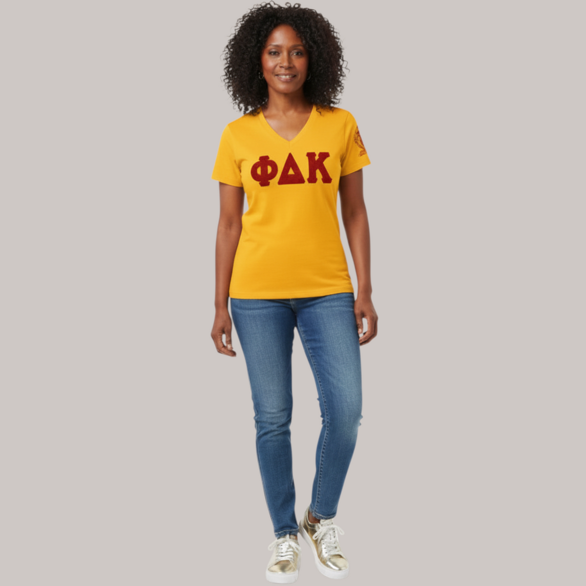 Pat Goffe Collections yellow v-neck t-shirt with red chenille ΦΔΚ lettering worn by a woman with curly hair