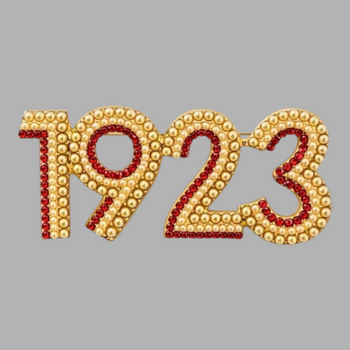 Pat Goffe Collections 1923 brooch featuring gold-tone metal, cream faux pearls, and red crystal accents.