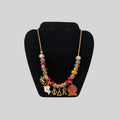 Pat Goffe Collections charm necklace featuring red and gold beads with Greek letter and crest charms on a gold chain