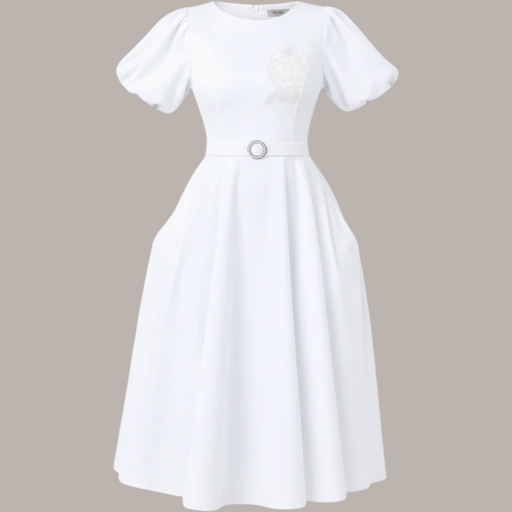 Pat Goffe Collections white midi dress featuring puff sleeves, a belted waist, and an embroidered NSPDK crest.